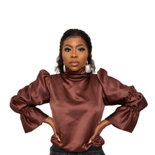 Load image into Gallery viewer, Description  100% poly Satin fabric Made in Sierra Leone  Dry clean only Fully Lined Puff sleeves Back tie closure  Flared sleeves Turtleneck  Color - brown Size &amp; fit  Modeled in size   Model measurement:   FOFIE - BLOUSE Size Bust Length Sleeve length XS	31	17	24 S	33	18	21 M	35	24	26 L	40	25	26 XL	42	26	26
