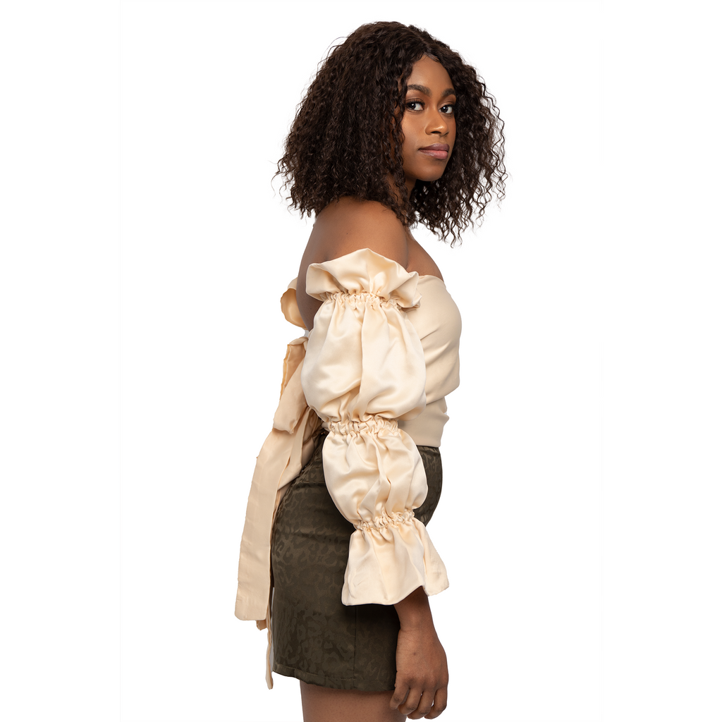 Cream puff sleeve with flared arms top. Open back tied closure.